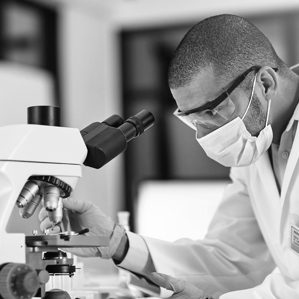 Man in mask at microscope