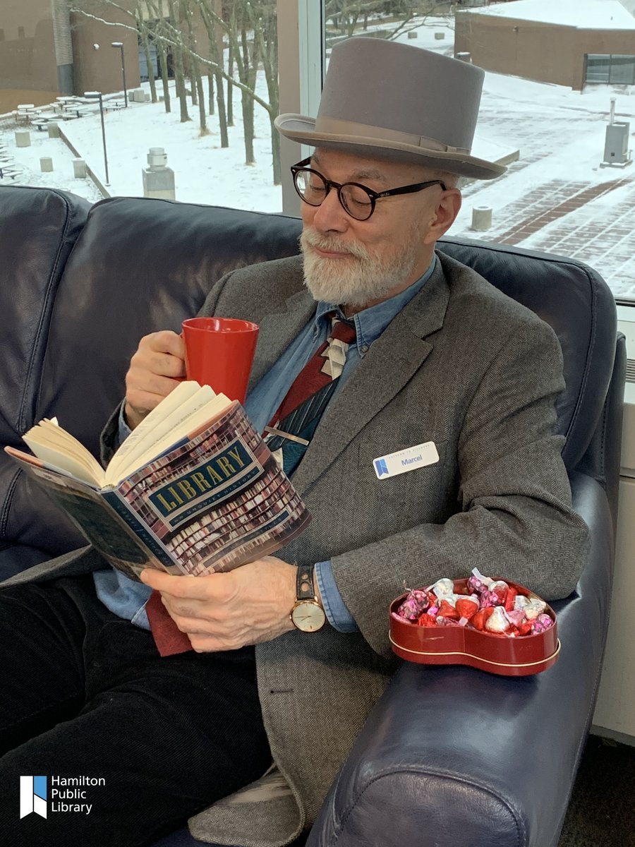 HamiltonLibrary's tweet photo. On this lovey-dovey day, it's fitting that it's #LibraryLoversDay too! #HPLStaff Marcel is deep in thought with his library-themed book of choice ... a perfect fit for today. #HamOnt #libraries #librarylove #librariestransform https://t.co/vjHXXu2Hqq https://t.co/lmA9qZhIap