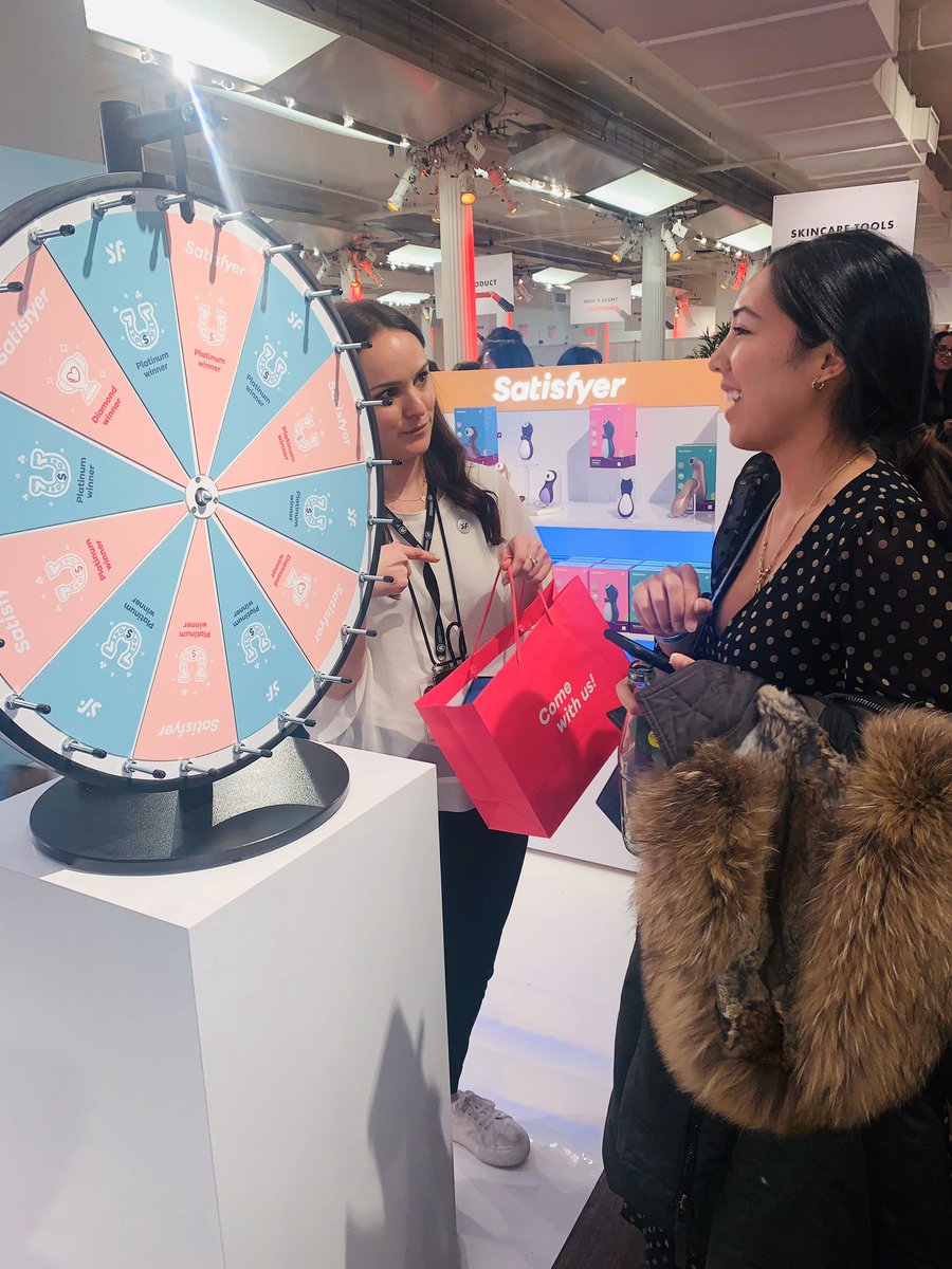 CEWinsider's tweet image. All smiles from our #CEWDemo attendees at the @SatisfyerCOM Wheel of Fortune, which had a line wrapped around its booth! Sexual wellness has become a top trend in #beauty.