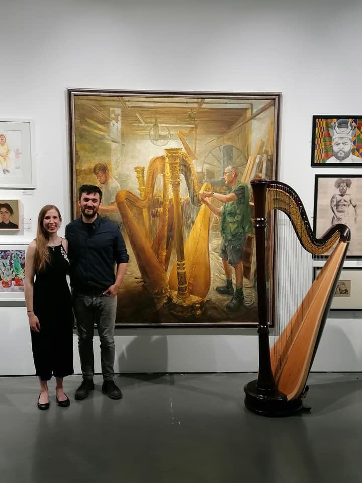 RoyalSocBritArt's tweet photo. Eleanor Dunsdon Harpist with Lewis Hazelwood-Horner. Lewis’s magnificent painting in the background @mallgalleries  @RoyalSocBritArt https://t.co/6zdzl8TP39