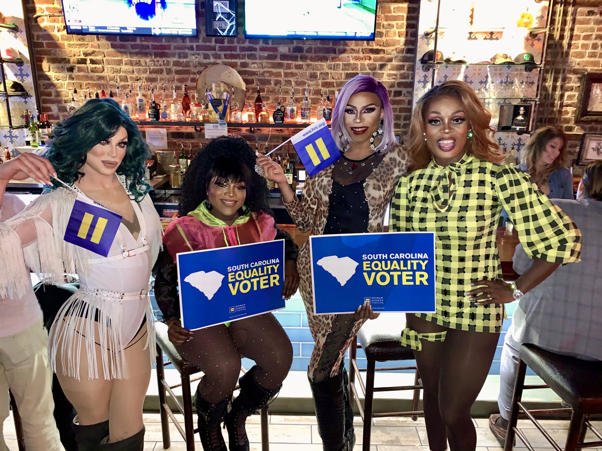 Drag queens holding North Carolina Equality Voter signs and flags