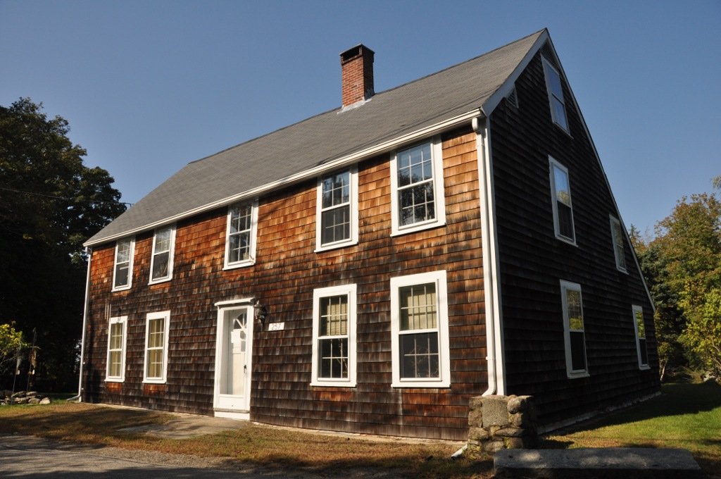 that house, and this one - which is even earlier, probably late 17th century - are of a distinctive local shape with the roof coming down further on one side than the other: they're called saltbox houses. many of the oldest houses in New England are saltboxes