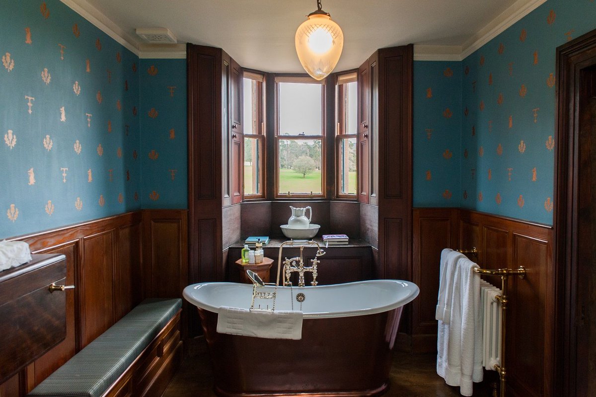 The fleur-de-lis symbol and that of one representing the Fraser-Tytler family of Aldourie Castle are depicted together in this bold and striking wallpaper in Turrett Bathroom #castleinterior #luxurybathroom