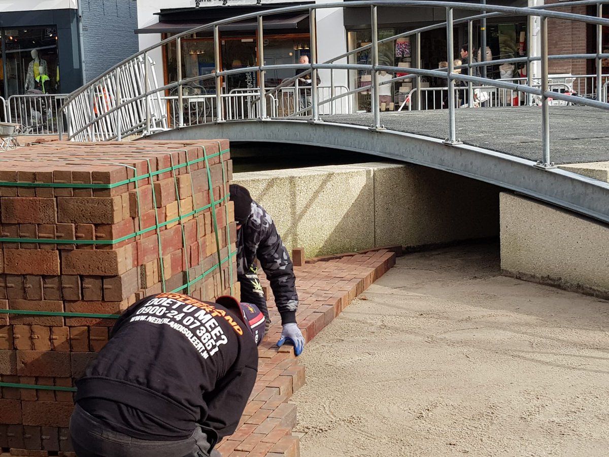 BinnenstadHGV's tweet photo. Herinrichting binnenstad #Hoogeveen, fase 2, dag 56: Steen voor steen wordt de nieuwe bestrating gelegd in onze fraaie binnenstad. Het is een flinke klus maar het wordt prachtig! De rode bestrating vormt straks in het voorjaar met de bomen en beplanting een fris en groen geheel. https://t.co/4FUZOB9Zv8