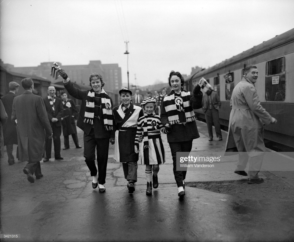 Fulham fans at Addison Road Station, where they are catching a Supporters Club train to travel to an FA Cup match against Ipswich Town, 1957.Photo by William Vanderson