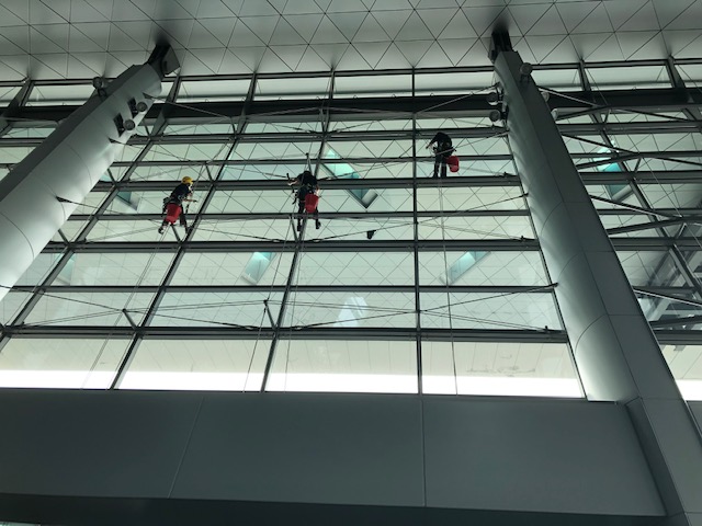 New Image High Access team keeping the amazing award winning Hamad International Airport in tip top condition.  Seen here cleaning the interior of Departures Glass Facade.