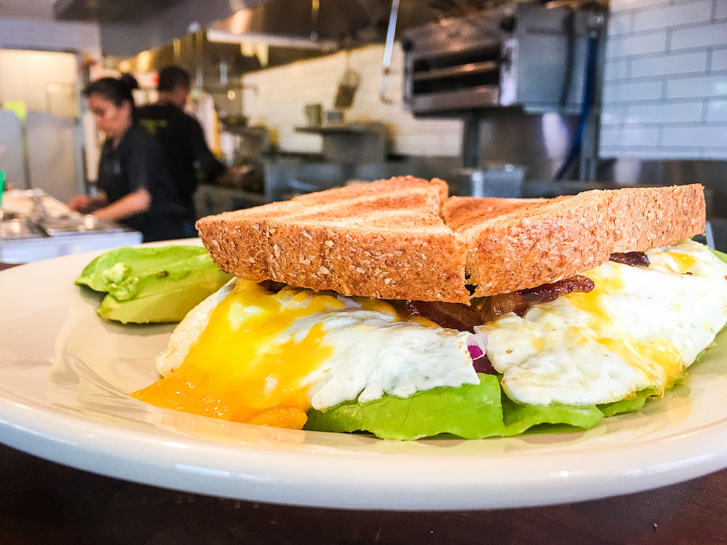 Our egg sandwich is made with two farm-fresh eggs over medium with your favorite add-ins: crispy bacon and sharp cheddar on 9-grain toast. If you aren't a morning person, you will be after this. #atxeats #localfood
