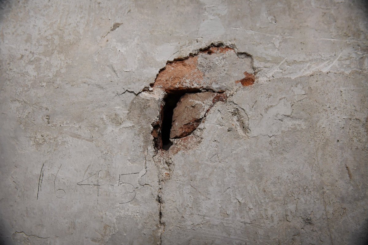 Masons and bricklayers blocked it up in the 1850s, leaving their names in graffiti on the walls. 