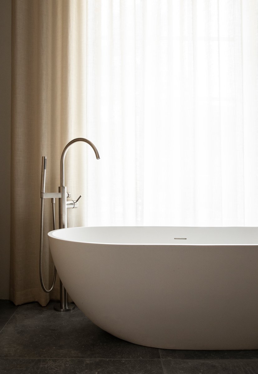 In the master bedroom of the Sandbjerg Residence, large oak doors open up to the bathroom, featuring bespoke cabinets and basins. All materials chosen for the interior are durable and easily maintained, only gaining beauty with time, wear and tear.