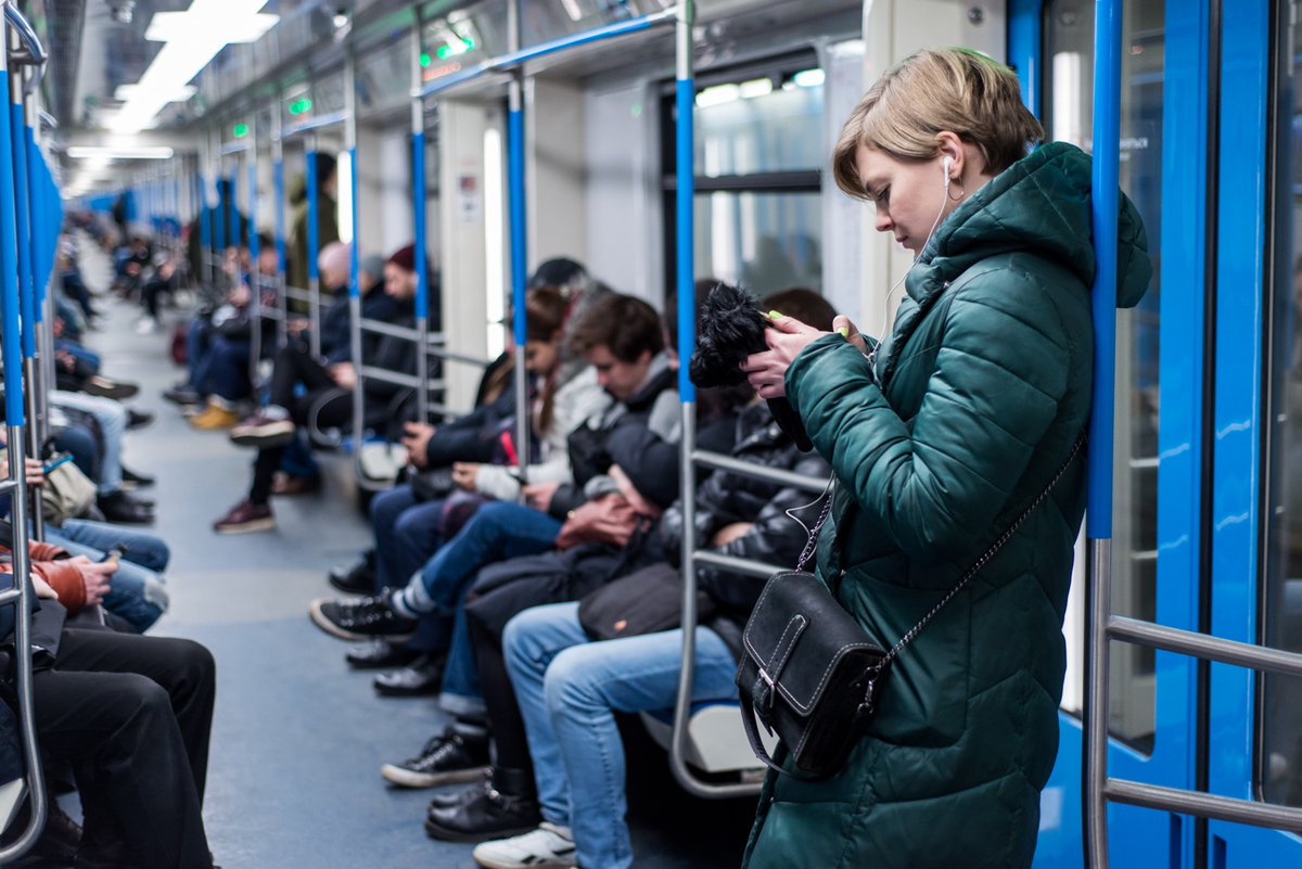 Метро мобильные телефоны. Люди в общественном транспорте. Люди в наушниках в метро. Люди со смартфонами в метро. Человек с телефоном в транспорте.