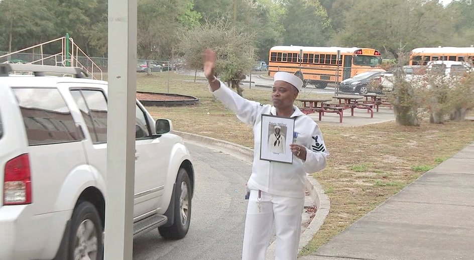 Angela Riley-Maxwel greeting students dressed as Navy Messman Doris Miller.