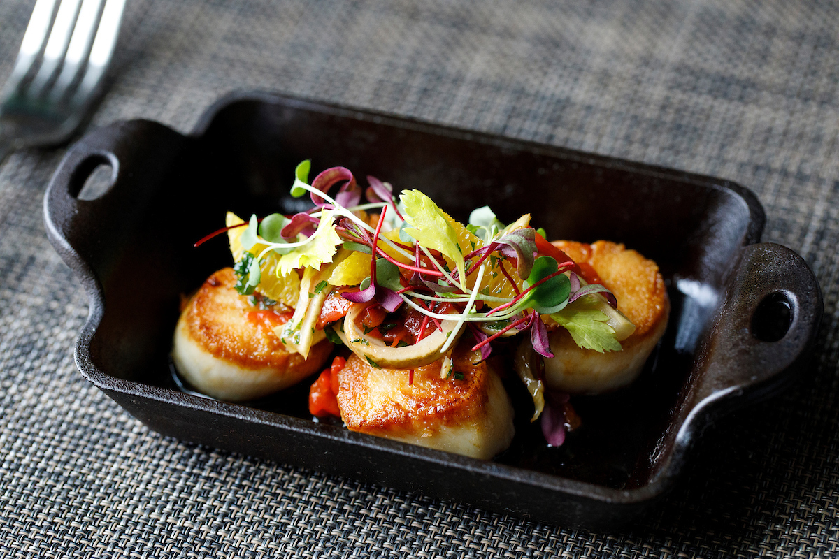 These sumptuous pan-seared scallops--topped with citrus piperade--make for a glorious meal in The Brasserie. Pair with one of many satisfying sides to attain perfection. We hope to see you for dinner soon  #WeekapaugInn #InnTheMoment #RelaisChateaux #DeliciousJourneys