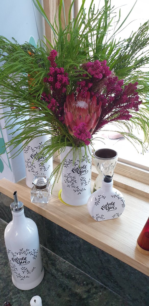 norfokgin's tweet photo. The window sill is popping with colour today.I'm calling the display flight of fancy.When our Norfolk Gin bottles have reached the end of their lives with us, Paul @greenbottleglass works his magic to repurpose them into decorative pots. #repuposed #ginbottle #norfolkgin https://t.co/gMmmFm63d3