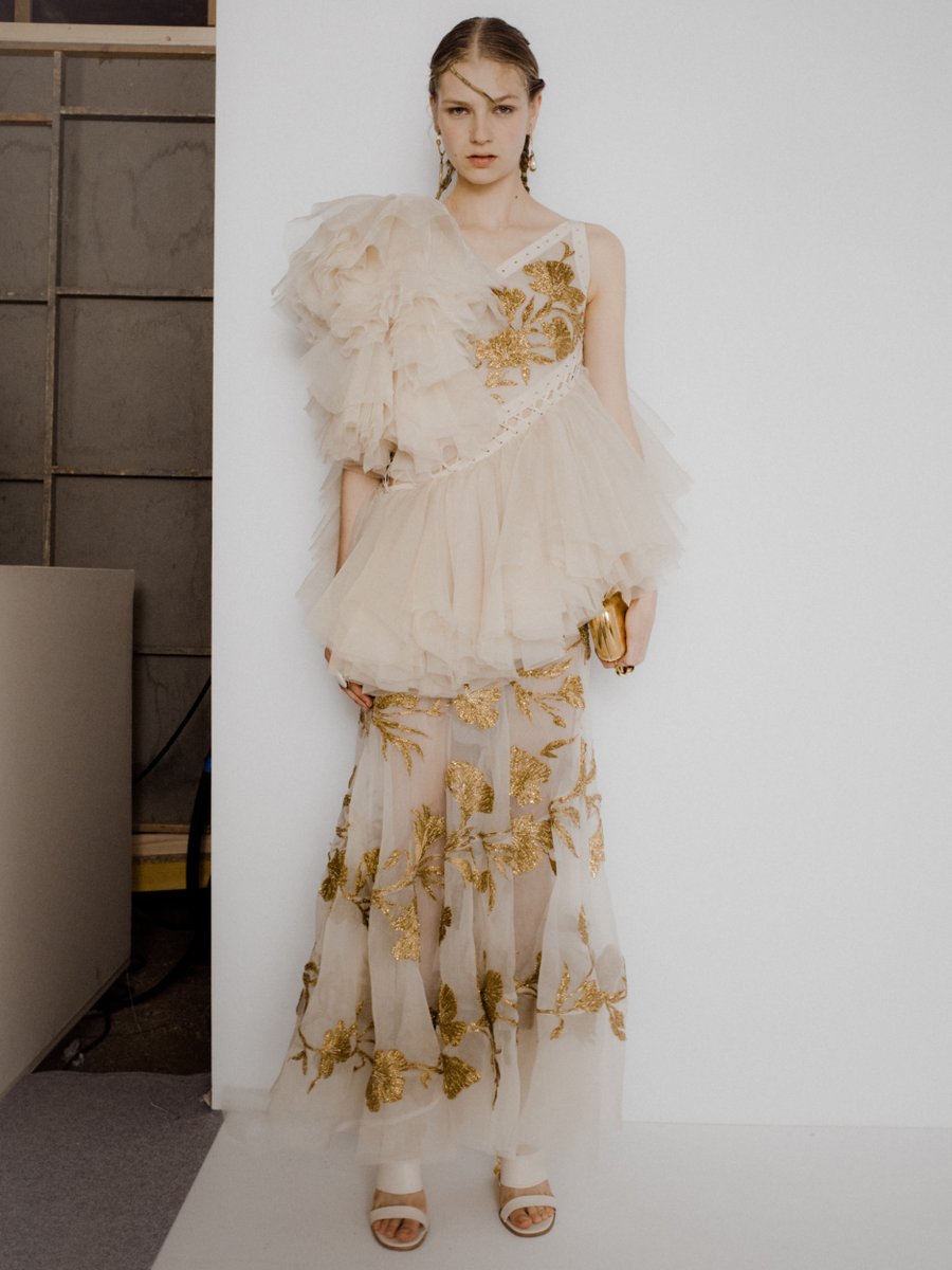 An exploded ruffle dress with white eyelet and cord detailing in calico  washed organza hand-embroidered with hammered gold bullion flax flowers.  From the Spring/Summer 2020 collection: https://t.co/5QGC0XeBIr  #McQueenSS20 #AlexanderMcQueen