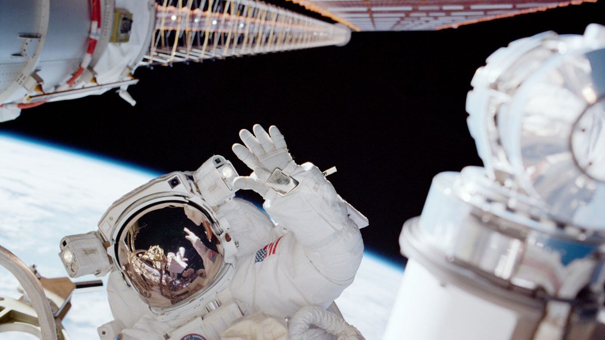 Astronaut waves during a space walk