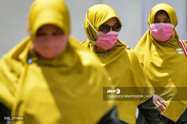 AFPphoto's tweet photo. #Indonesia 
Women wearing face masks walk in a public area in Banda Aceh. 
A picture by #AFP photographer  @mirroreye https://t.co/VCBP1pEXjP