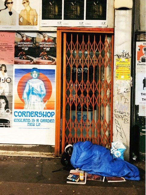 hellothmushroom's tweet image. I don't usually take this type of photos but the man sleeping rough with the "England is a Garden" poster just kind of made it  very ironic. I'm sure @TjinderSingh meant it like that too.