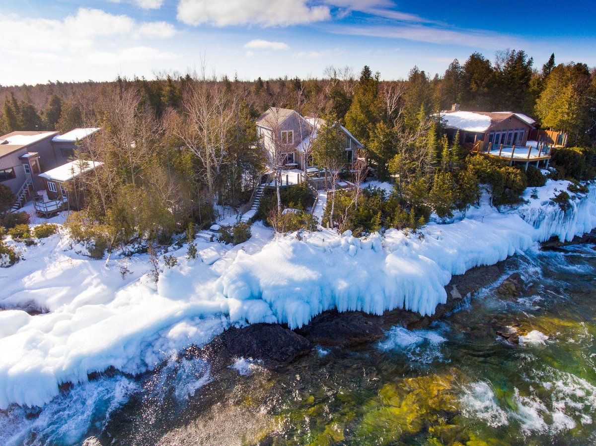 Lampstandvisual's tweet photo. Look at the ice formation at the edge of this waterfront cottage in Tobermory! #realestate #cottage #drone #photography #greybruce #lakehuron #georgianbay #ice #winterdrone #blueskys https://t.co/4bTh89zXnd
