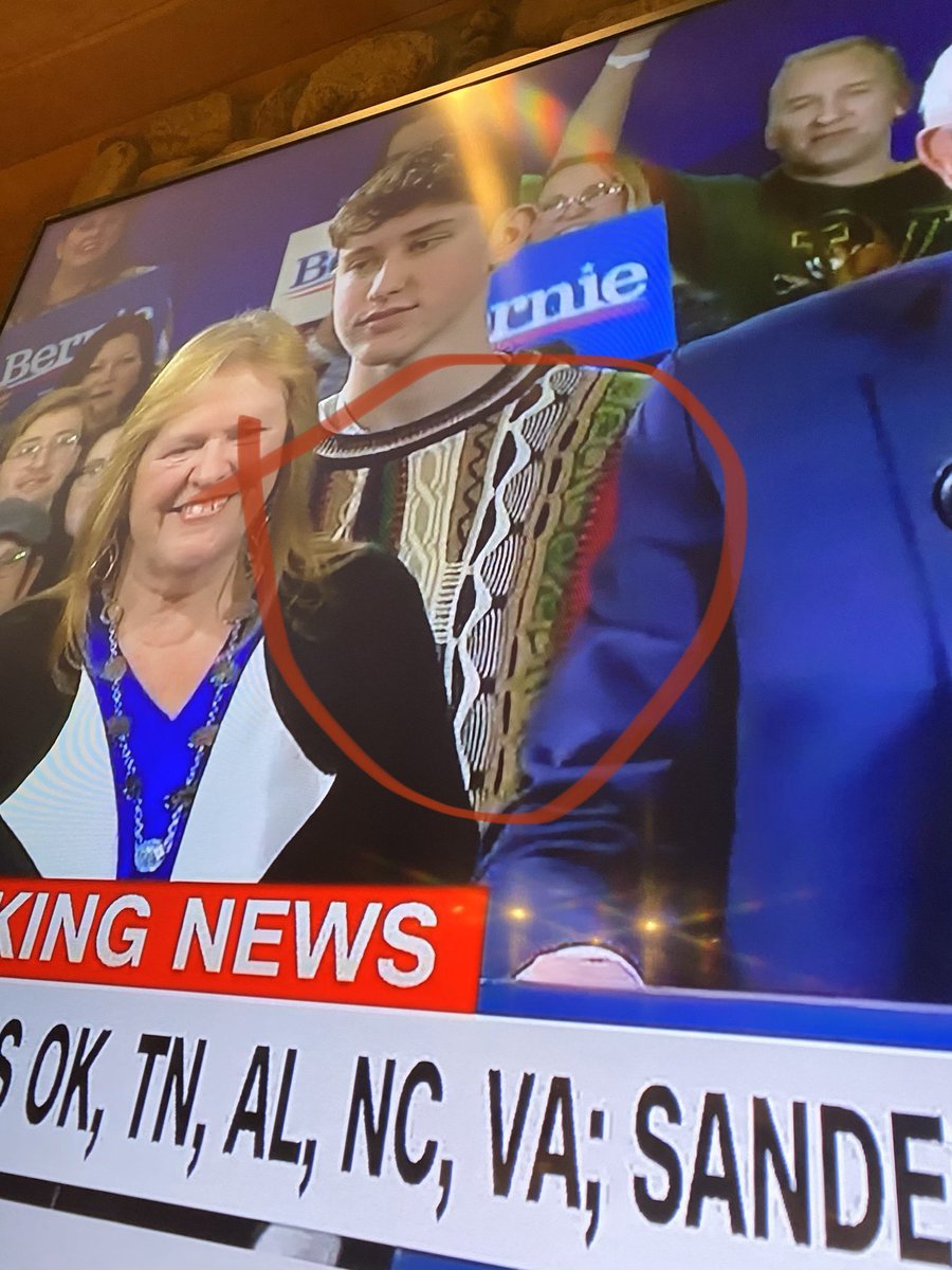 scottbush's tweet photo. Not sure who is winning the votes for president, but best sweater goes to this guy behind Bernie https://t.co/Cy9kYO6Shh