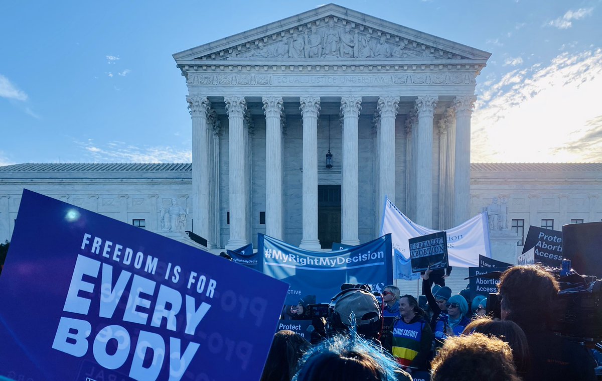 A photo of the US Supreme Court with a protest sign that says “Freedom is for every body”