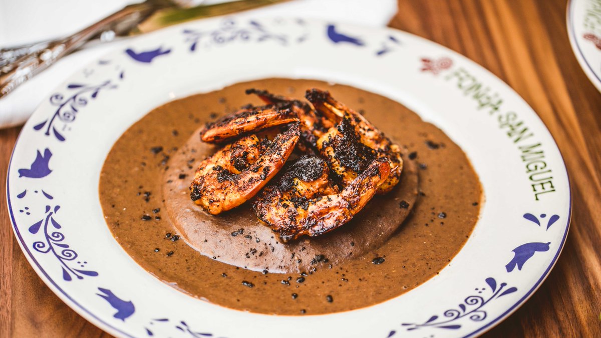 Savor the rich flavor of our Camarones Adobados | Adobe-crusted Gulf shrimp placed over corn tortillas filled with rajas &amp; served with a chipotle-black bean sauce