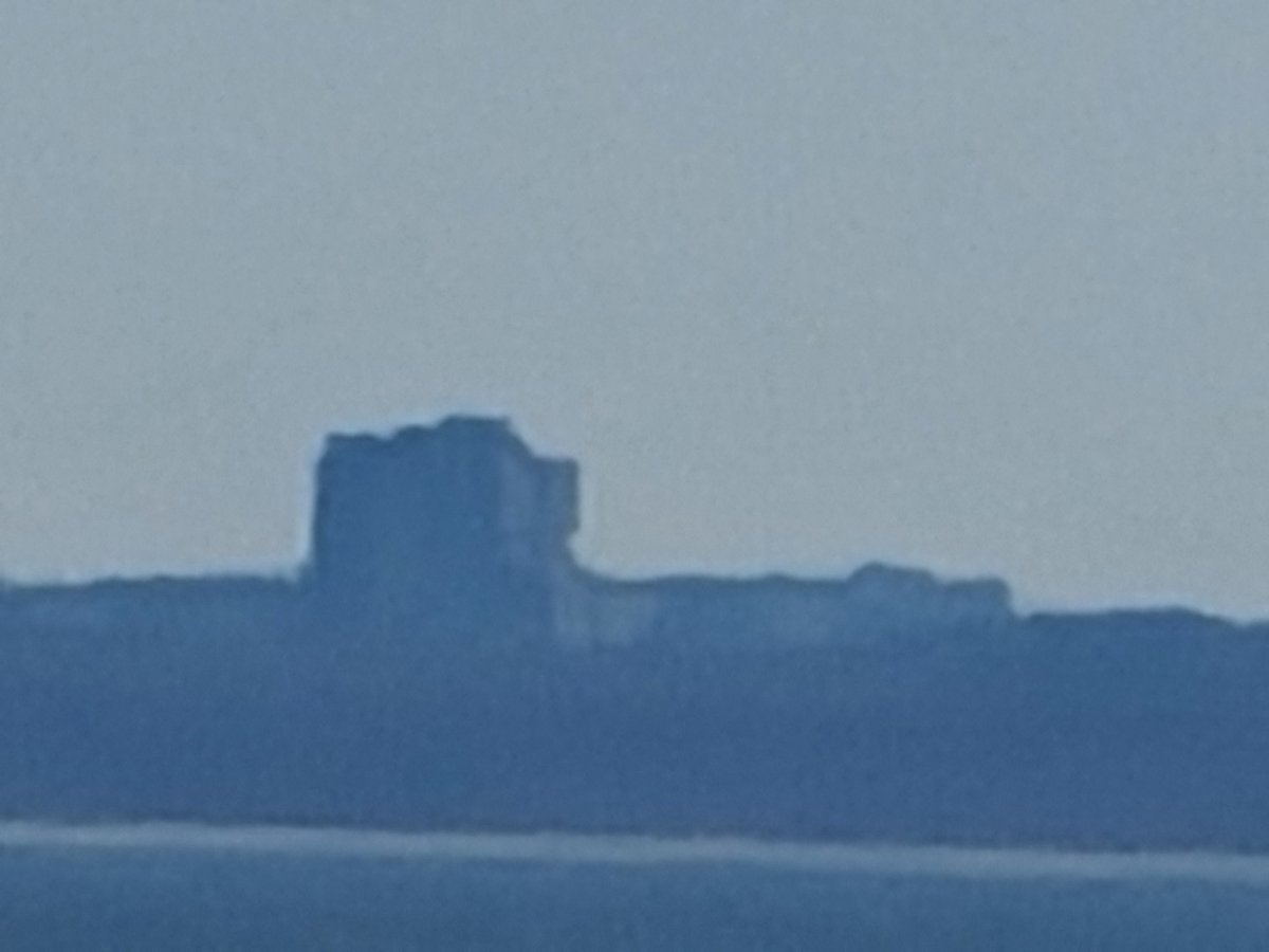 mweinbach's tweet photo. It's hard to tell what this is, sure, but this is, I believe, the Pilgrim Psychiatric Center in Long Island. This is 35 miles away across the Long Island Sound. It's at 100x zoom from the S20 Ultra. It's kinda insane to get a photo like this. https://t.co/LXl1iiufrL