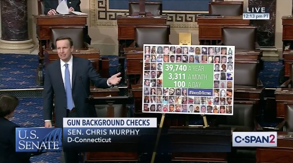 Senator Murphy speaks on the Senate floor to honor victims of gun violence. He has a poster next to him with faces of victims.