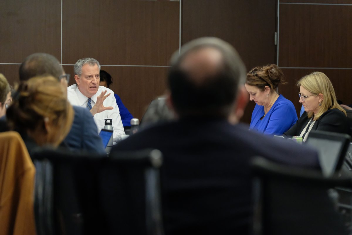 A photo of the Mayor sitting at the head of a table.