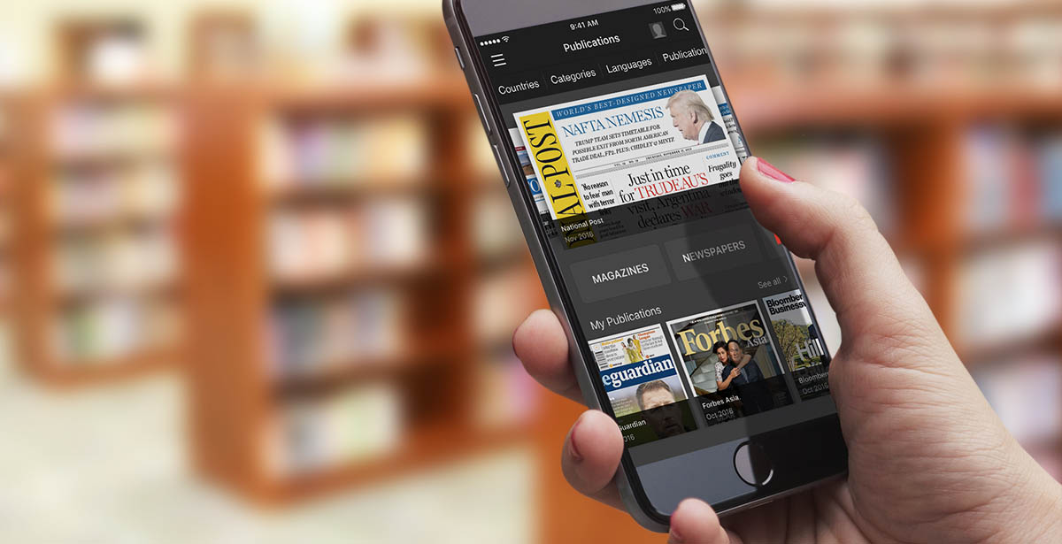 a man holding up a phone. smartphone's screen displayed showing the Press Reader app with magazine covers displayed