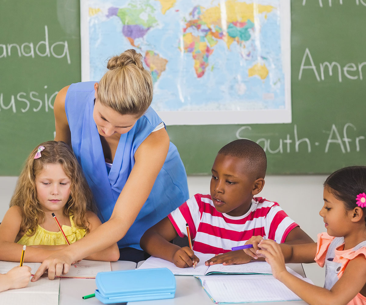 Teachers know that the most. Школьный класс. teacher help. the kids are doing their homework.. school class with kids chalkboard view.