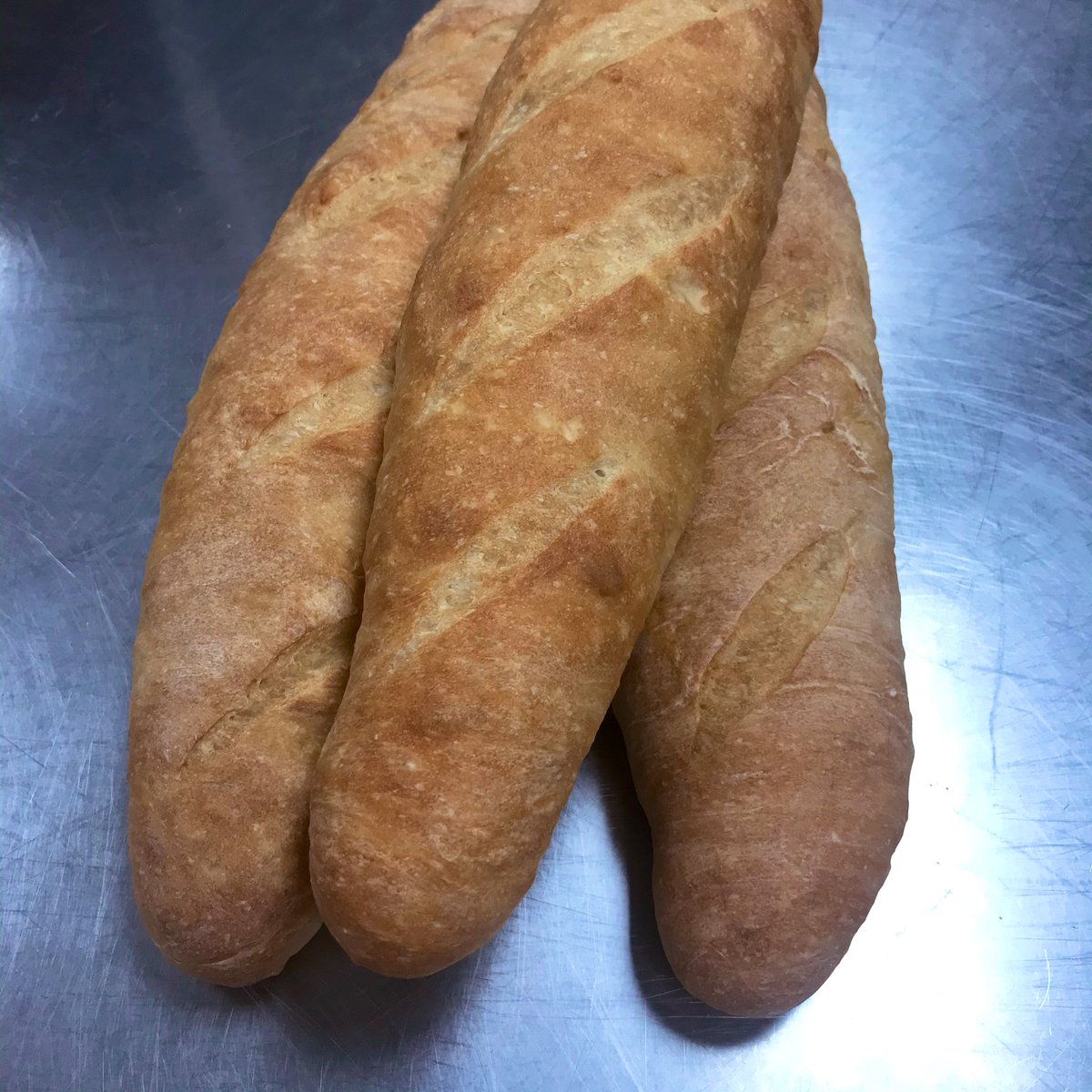 MainStCookery's tweet photo. A trio of #baguettes mixed using the autolyse method. At this point in the semester I’m really working on slashing the loaves consistently. #lotsofpractice #artisanbreads https://t.co/uDtf3FqMzT