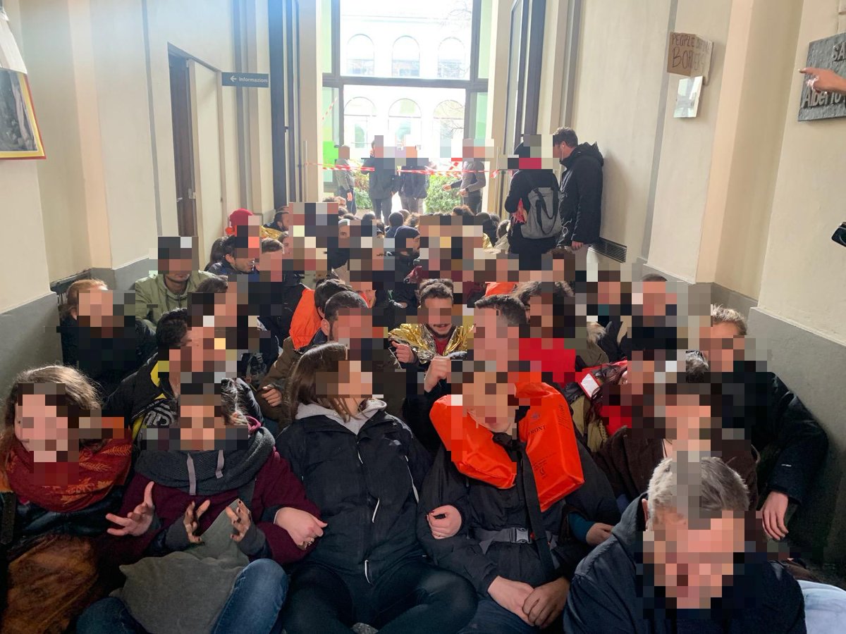MeltingPotEU's tweet photo. Continua l'occupazione dell'atrio della Commissione EU a #Milano. I manifestanti sono seduti a terra all'interno. Lo striscione è stato esposto sul balcone. Minacciato l'intervento della celere #lesvoscalling #EUSHAME #OPENTHEBORDERS #6marzo https://t.co/pMJZX8aolw