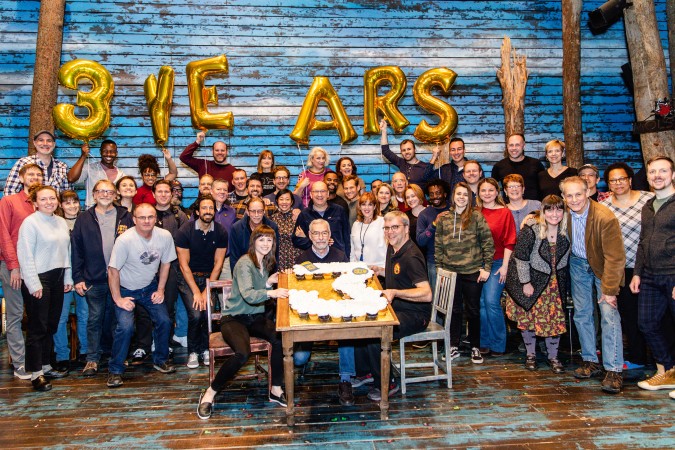 Photo of the company in front of a number 3 made with cupcakes