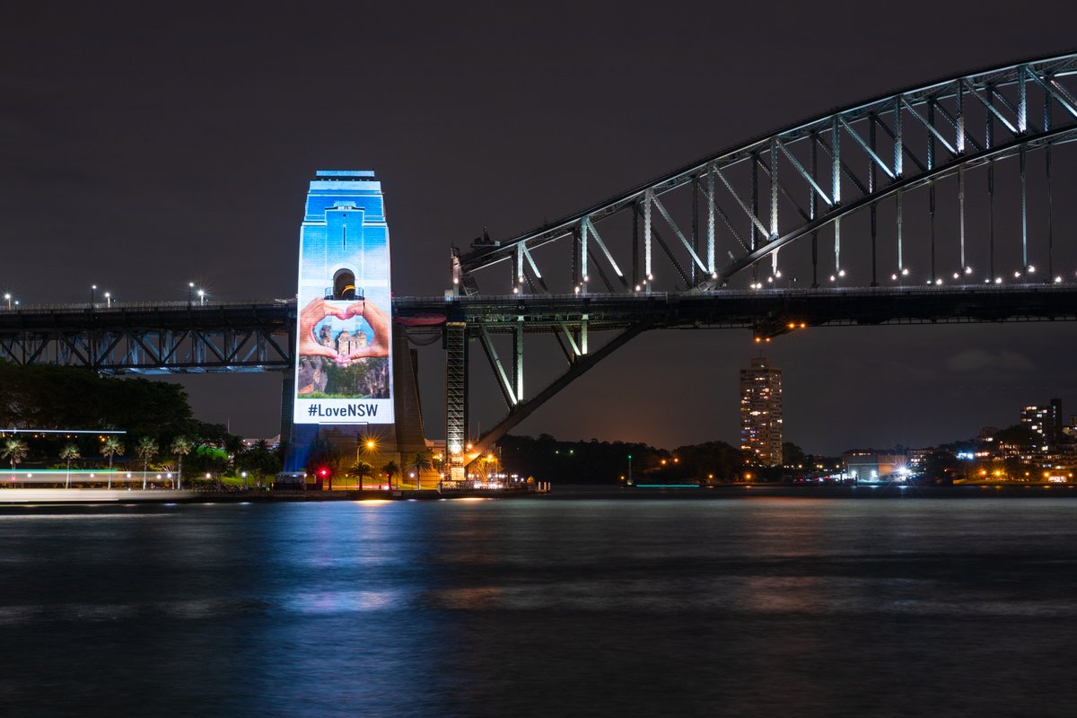 destinationnsw's tweet photo. Last night the southern pylon of the iconic Sydney Harbour Bridge was illuminated with stunning pictures from across New South Wales. From beach to bush, mountains to outback, city to country, it's clear why so many people #LoveNSW! Where are you visiting next? #RecoveryWeekend https://t.co/A8dP3o00zU