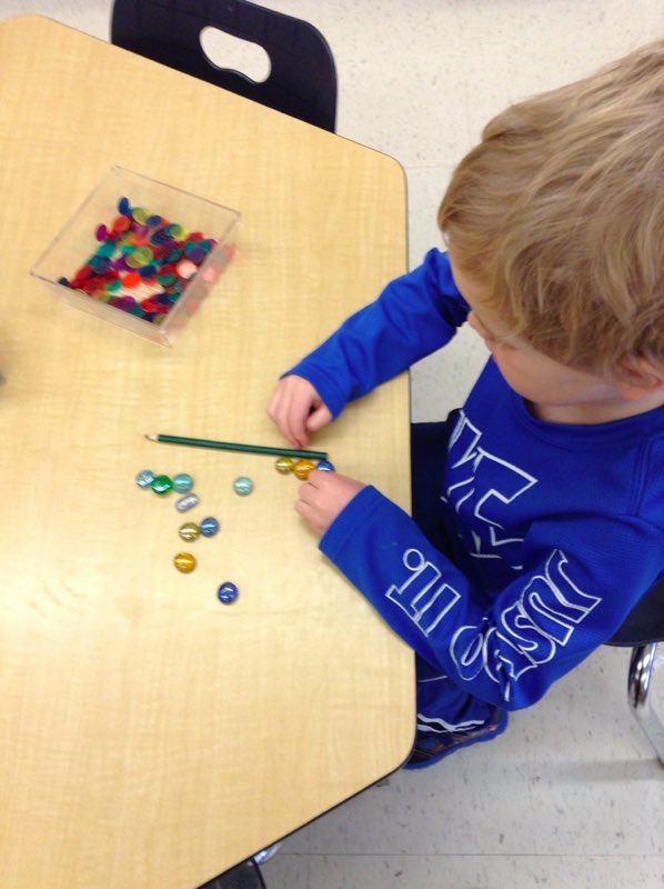 Doing a little measuring and comparing the length of this pencil to some stones. Great way to enhance 1 to 1 correspondence!! @EY_uwindsor