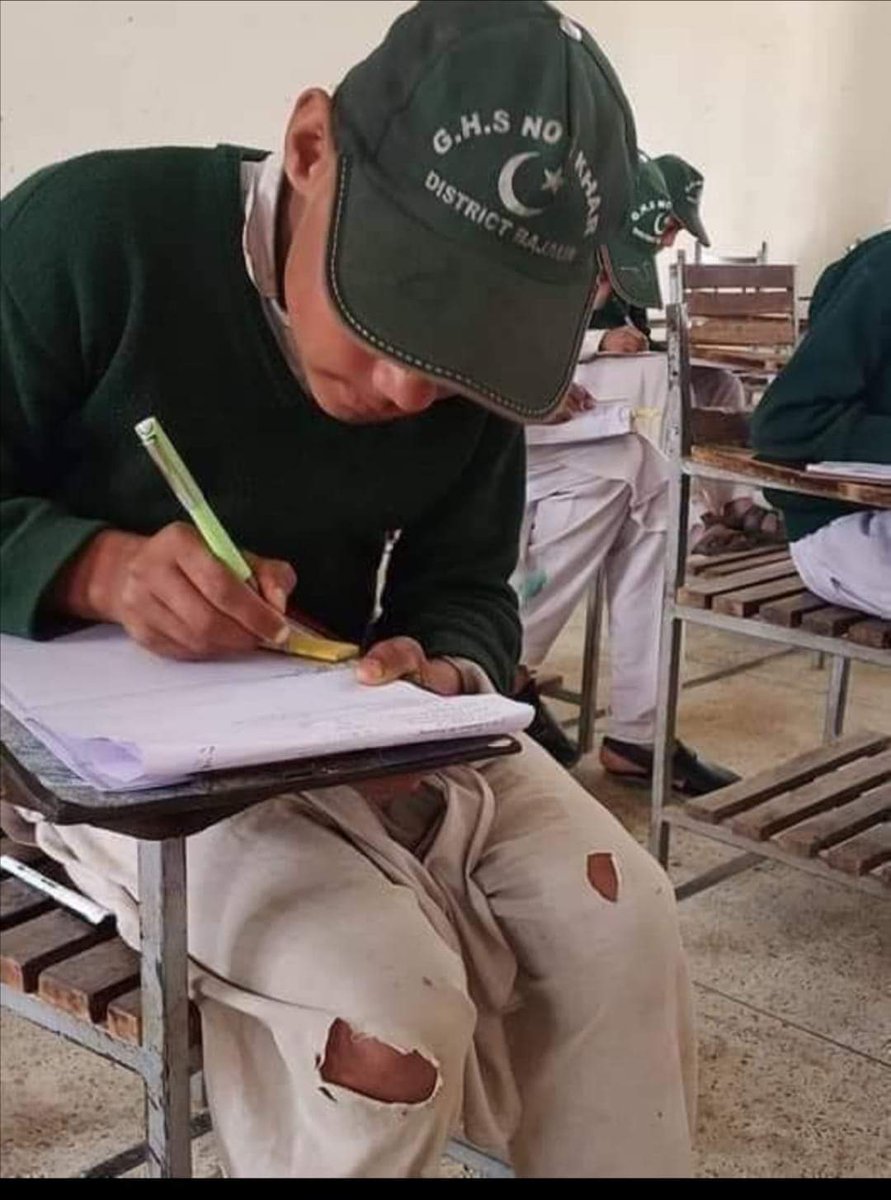Udhyaana's tweet photo. A Student with torn clothes is attempting his paper ina school at  #Bajour. 
#Respect 
#poverty https://t.co/TXywIn62n2