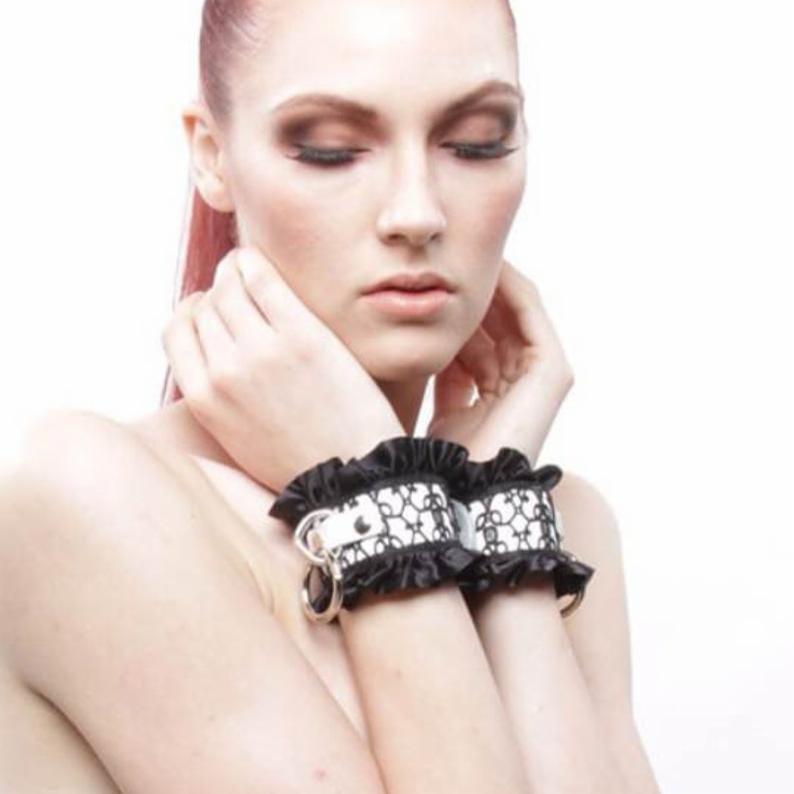 The Ingenue cuffs quiet presence will no doubt leave an impression with pristine belt weight white leather which has been bound to the exotic frills of black filigree lacework.  Don't let the delicate appearance fool you, this Liquid Nymph creation was made to last! #sissymaid