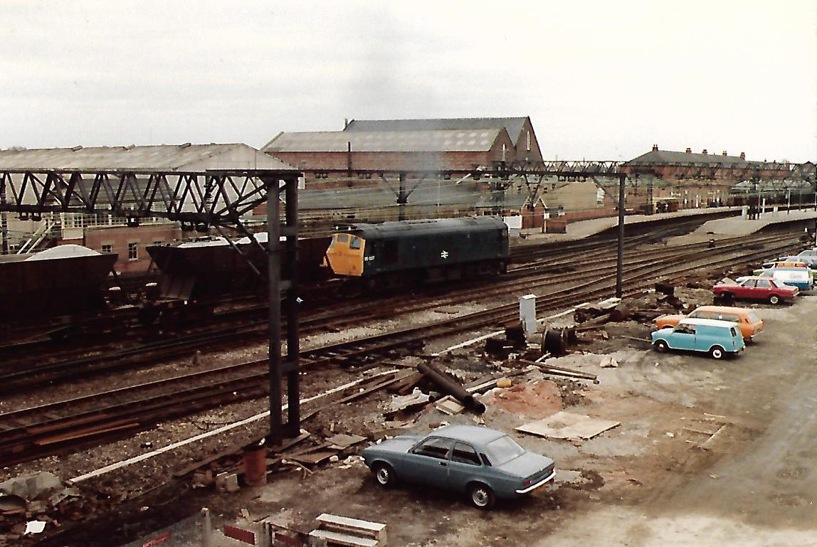 Some period Cars & Vans parked up as British Rail Class 25 Sulzer Type 2 Diesel 25 027 heads loaded ICI Bogie Limestone Hoppers in to Guide Bridge station 3/2/83 #Railfreight #trainspotting #BritishRail #Class25 #Diesel  #Manchester #80sCars 🤓