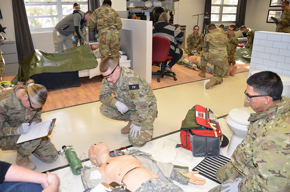 MilitaryHealth's tweet photo. Combat medic trainees engage in various scenarios in the emergency medical technician (EMT) residential lab at the @metc_mil. The newly-designed EMT simulation labs resemble real environments that expose students to lifelike patient encounters. https://t.co/8NvykUAs8T