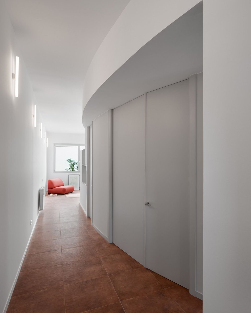 dezeen's tweet photo. A curved corridor with full-height doors slices through this ground floor home near Barcelona: https://t.co/JAwdibgXs7 https://t.co/KkTGGwlaQ7