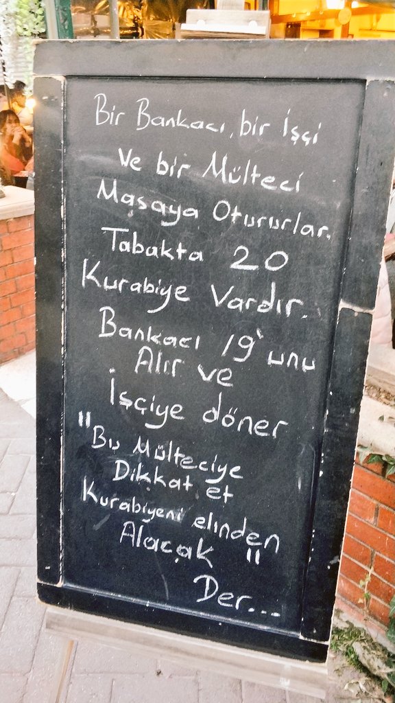 Bir bankacı, bir işçi ve bir mülteci masaya otururlar. Tabakta 20 kurabiye vardır. Bankacı 19'unu alır ve işçiye döner: 
"Bu mülteciye dikkat et kurabiyeni elinden alacak" der.