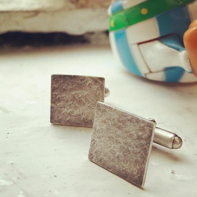 querc's tweet image. Oxidised Struck cufflinks on my studio windowsill today with my fave wind-up Obelix (everyone should have one). When they’re first oxidised they are a flat dark grey but wire wool and a gentle layer of wax brings them to life. ift.tt/3aMbvUH