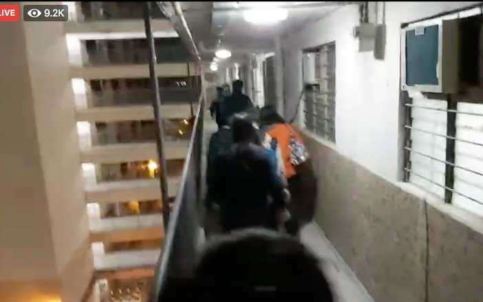 XinqiSu's tweet photo. #NOW Democrat Cheng Lai-king, chairwoman of Central and Western District Council, (in orange outfit) was taken by police from her home after a close-door search. via @StandNewsHK live. https://t.co/nTNzjYB7LI