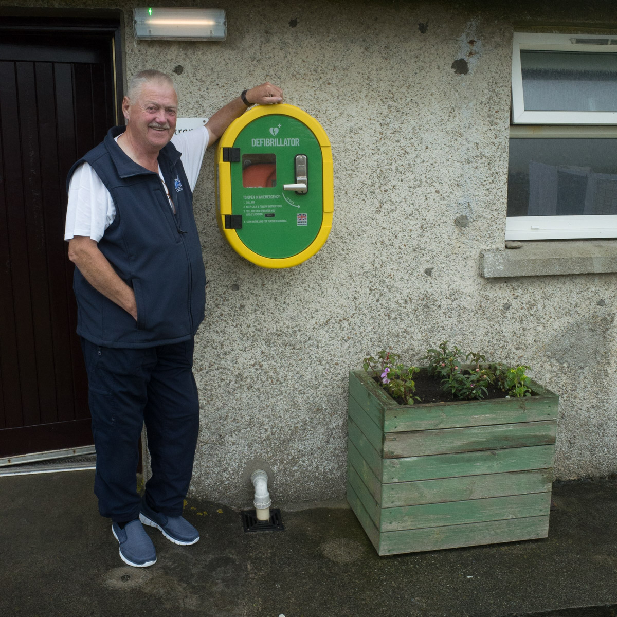 Charels Hepburn, retired Police Officer and Mountain Rescuer, with the defibrillator he fundraised for in memory of his wife, Birsay Campsite, Birsay, Orkney, Scotland  #WeAreHighlandsAndIslands  #TheHillsAreAlwaysHere