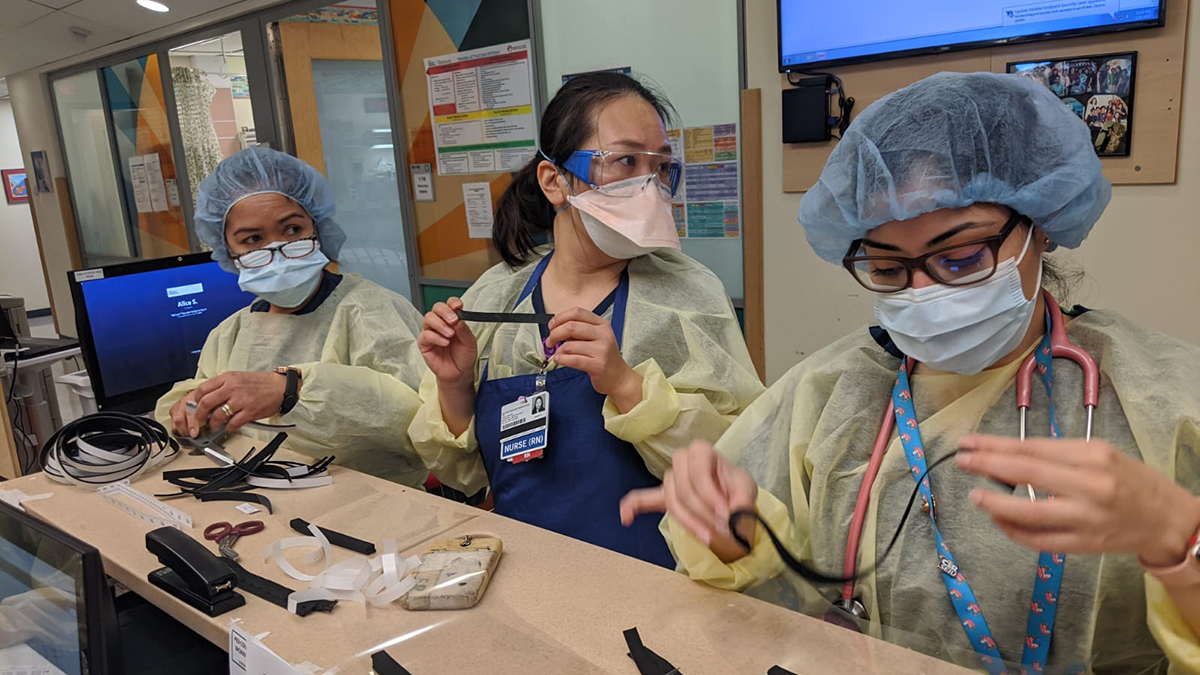 Health care workers constructing face masks.
