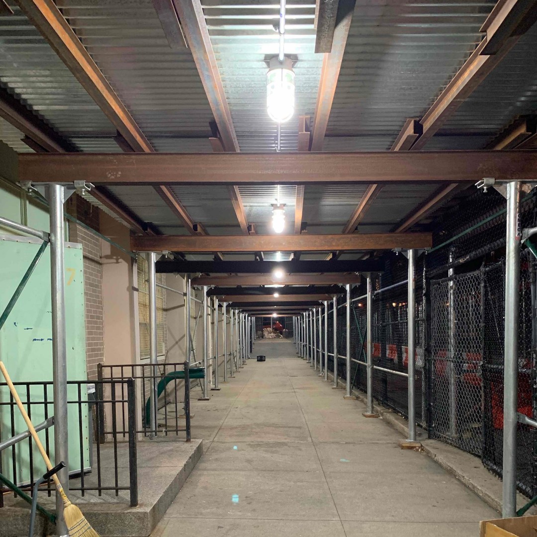 LitehouseBuild's tweet photo. During construction 🏗️, public protection is always a priority. In the picture, PS038K shed is completed and lit up. Ready for pedestrians to walk safely while work takes place! 👷‍♀️👷 #LitehouseBuildersInc #Construction #SidewalkBridge #Scaffold https://t.co/kyRB1dVLqd