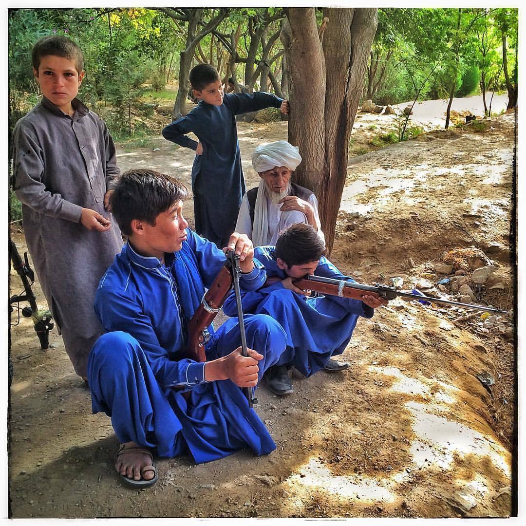 People of Herat: Teenage brothers practicing shooting and playing with rifles in a park.Photo by Morteza Herati.