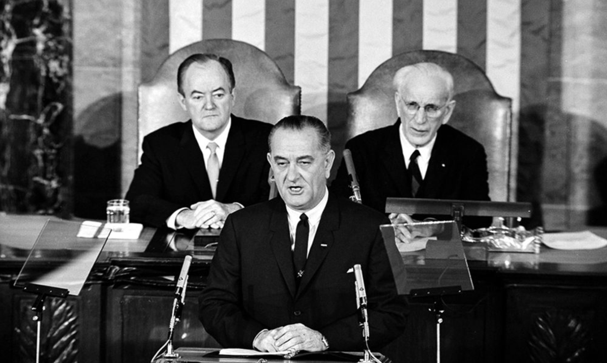President Lyndon Johnson delivers his speech urging Congress to pass a voting rights bill. Behind him are Vice President Hubert Humphrey and Speaker of the House John McCormack.
