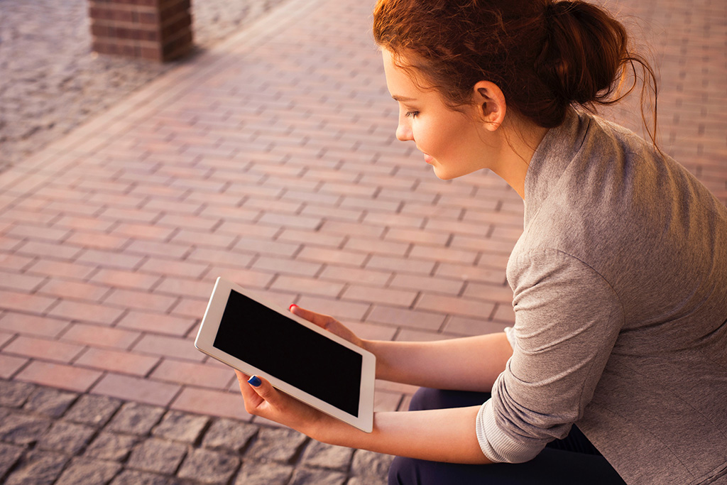 a young woman holding a tablet
