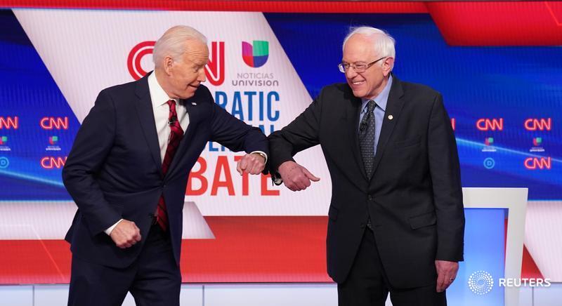 Former Vice President Joe Biden and Senator Bernie Sanders do an elbow bump in place of a handshake as they greet other before the start of their debate, held in CNN's Washington, D.C., studios without an audience because of the global coronavirus pandemic
